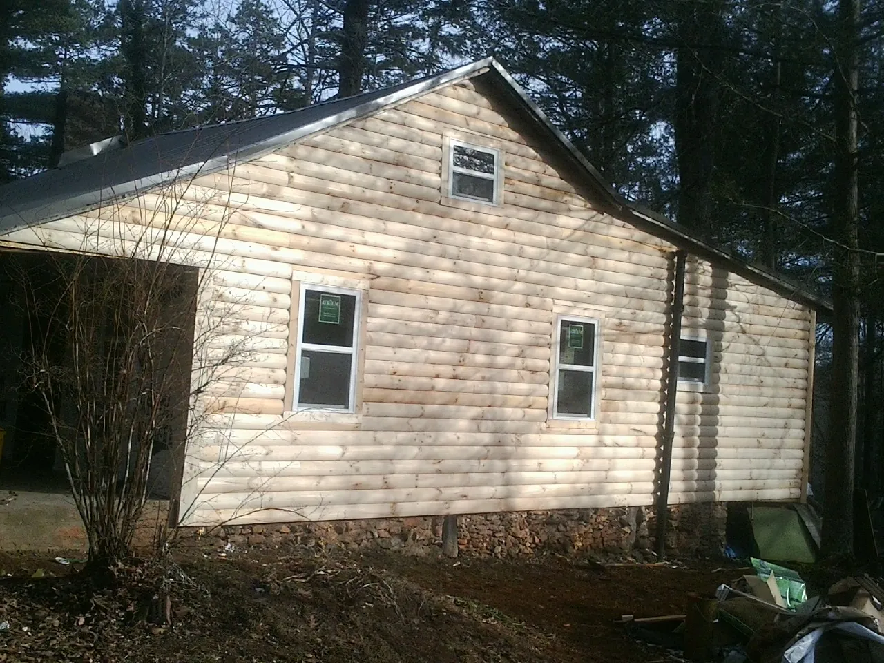 New log siding and dark metal roofing on a gable end in Quincy